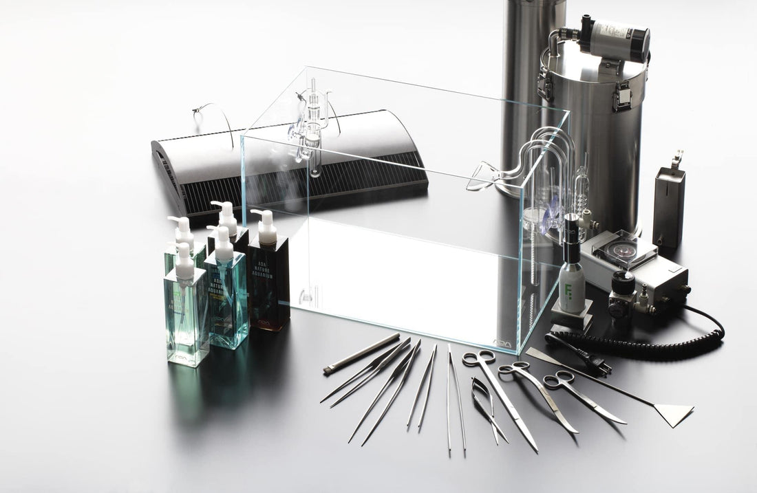 A collection of aquarium tools and products, including glass containers, cleaning supplies, and precision instruments on a sleek surface.